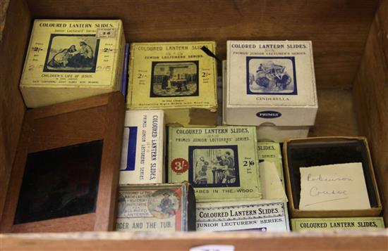 A collection of twenty one boxed lantern slide sets and a tin bodied magic lantern, late 19th / early 20th century,